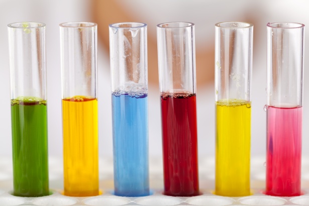 5 clear test tubes with different colors of liquid