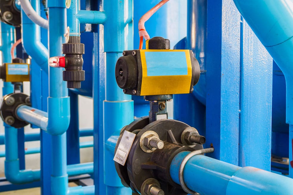 a close up of a blue pipe with a yellow valve